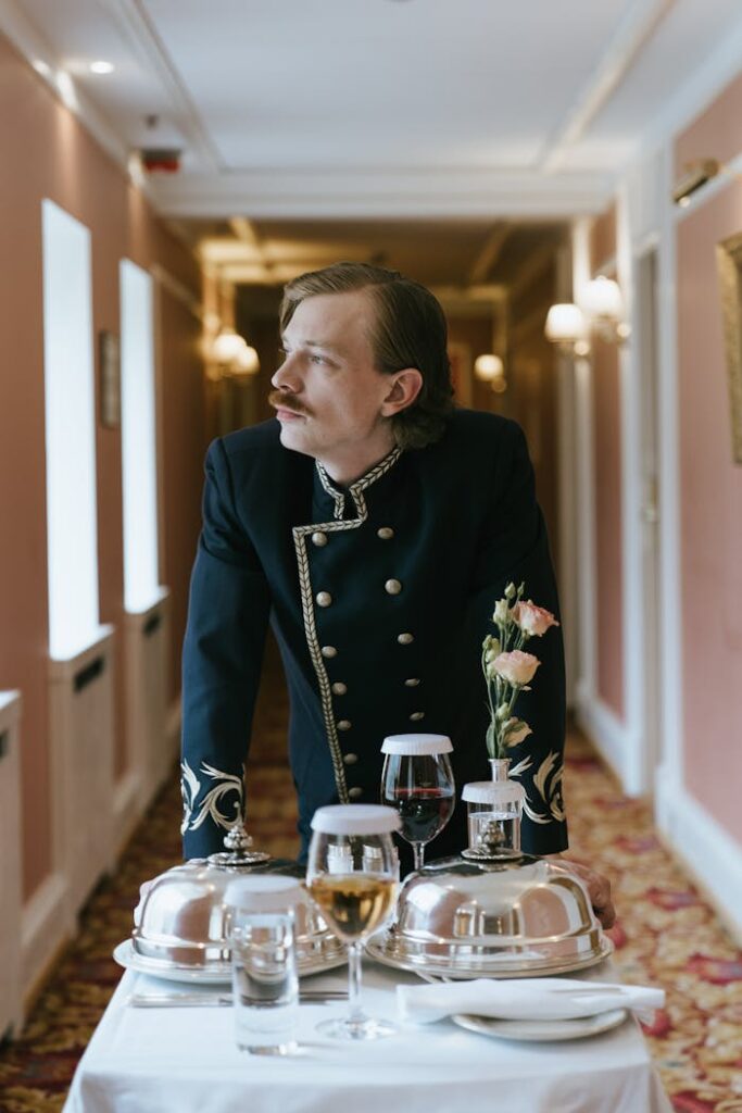 Formal hotel staff serving room service with elegance and style in a luxurious hallway setting.